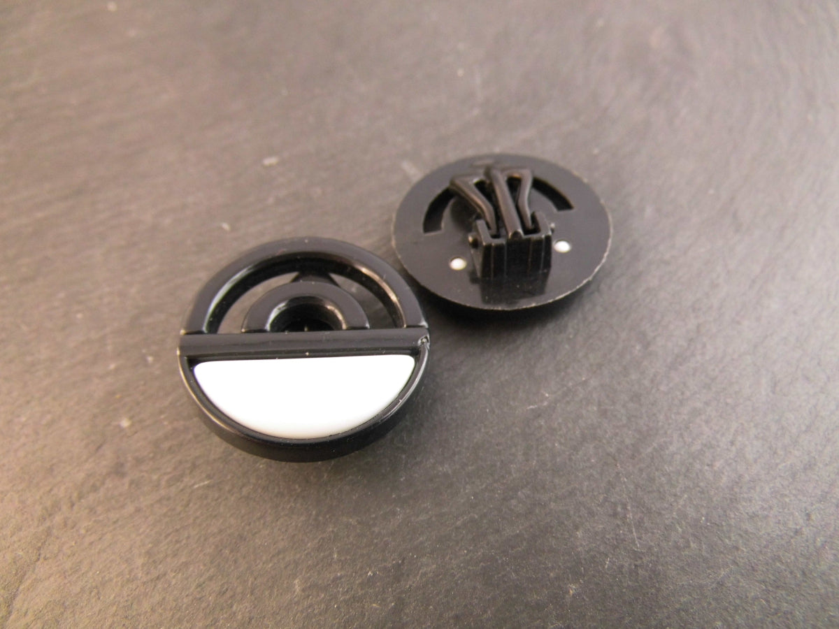 Vintage Ohrclips im geometrischen Design aus schwarzem Kunststoff mit weißer Einlage und Clipverschluss.